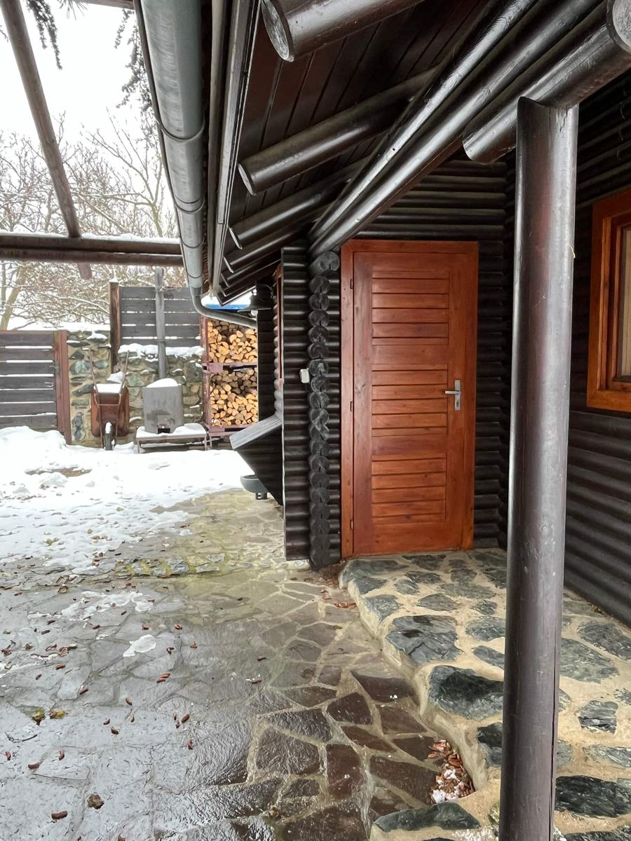 Dveře srubu a kamenný chodník